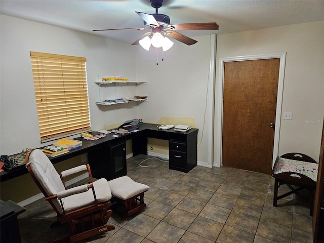 tiled office space featuring ceiling fan and a textured ceiling