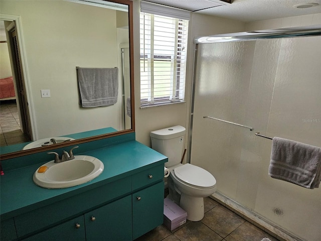 bathroom featuring toilet, a shower with shower door, vanity, and tile patterned flooring