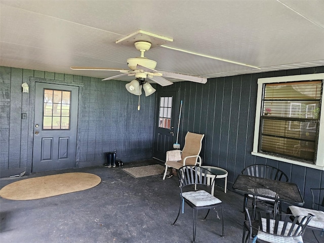 entrance to property with ceiling fan and a patio area