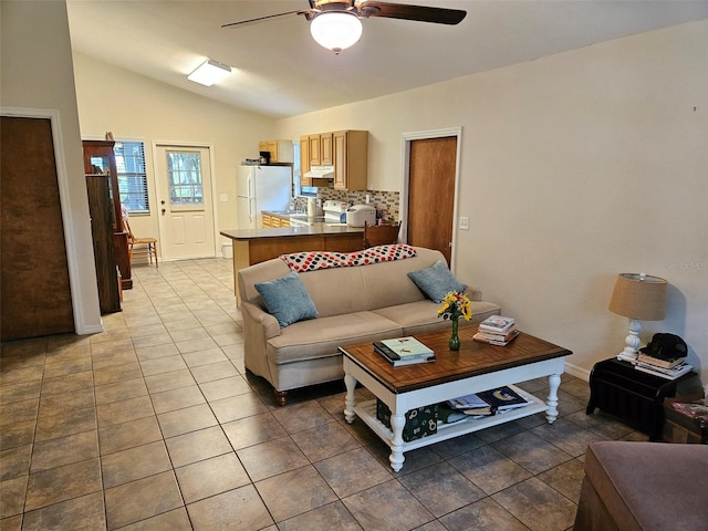 living room with ceiling fan, vaulted ceiling, and tile patterned flooring