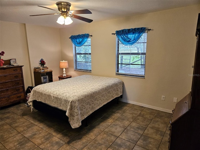 tiled bedroom with ceiling fan and multiple windows