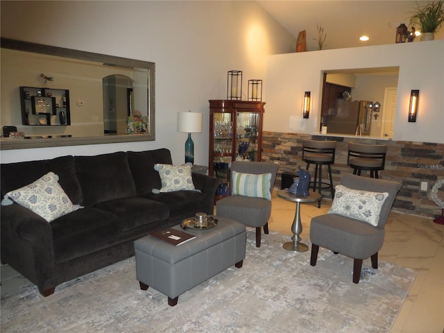 living room with high vaulted ceiling and light tile patterned floors