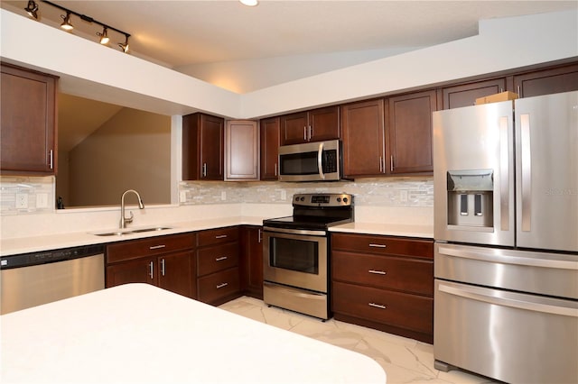 kitchen with backsplash, light countertops, marble finish floor, stainless steel appliances, and a sink