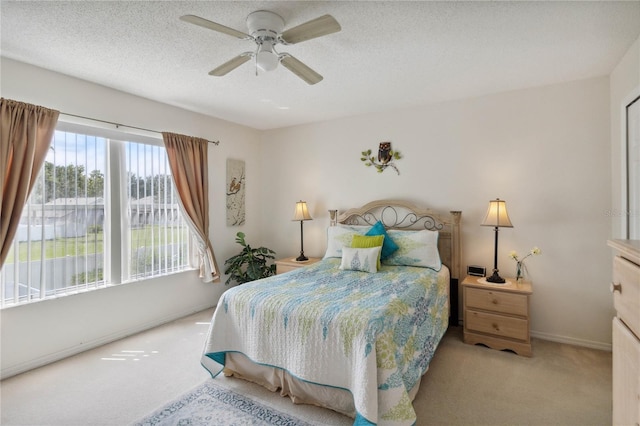 carpeted bedroom with ceiling fan and a textured ceiling