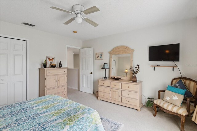 bedroom featuring a closet, ceiling fan, and light carpet