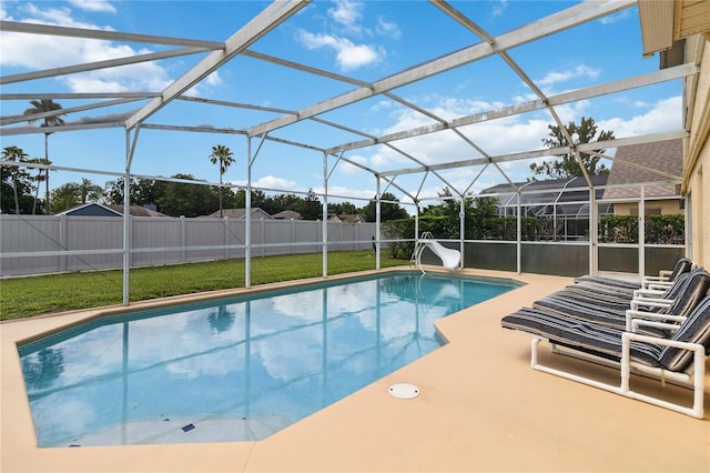 view of swimming pool with glass enclosure, a patio area, and a lawn