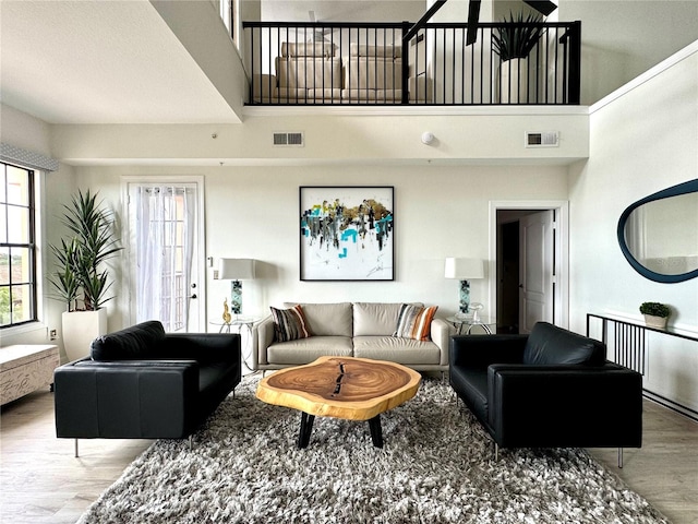 living room with a high ceiling and light hardwood / wood-style floors