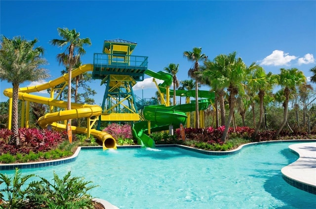 community pool featuring a water slide and a water play area