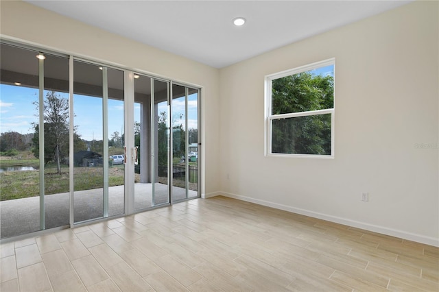 spare room with a healthy amount of sunlight and light hardwood / wood-style flooring