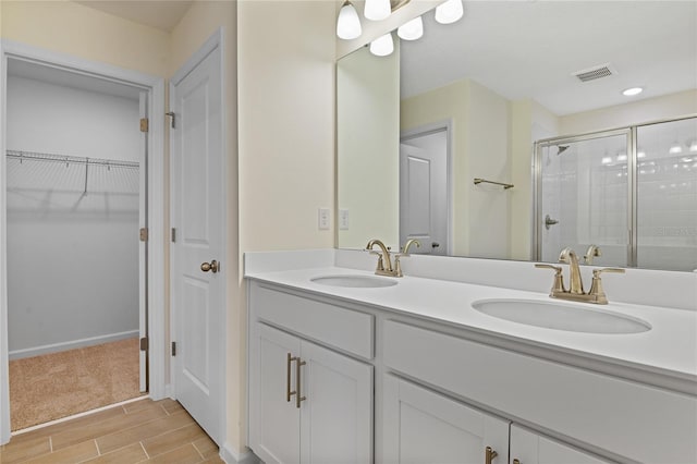 bathroom featuring a shower with door, vanity, and wood-type flooring