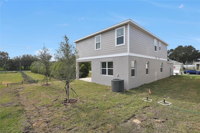 view of side of home with central AC unit and a yard