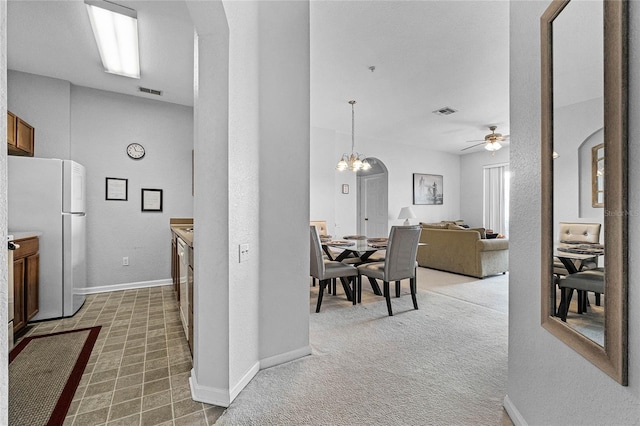 hallway with carpet floors and a notable chandelier