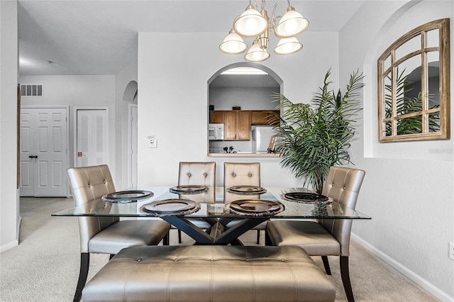 dining room featuring an inviting chandelier and light carpet