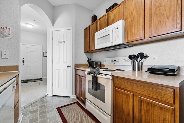 kitchen featuring light tile patterned flooring and white appliances