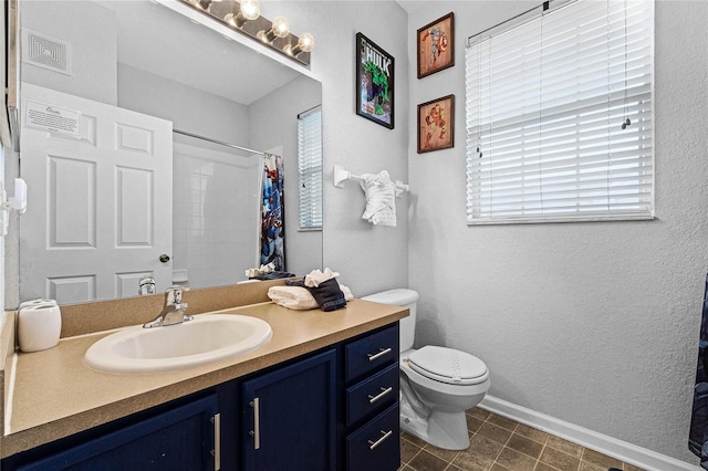 bathroom featuring tile patterned flooring, vanity, and toilet