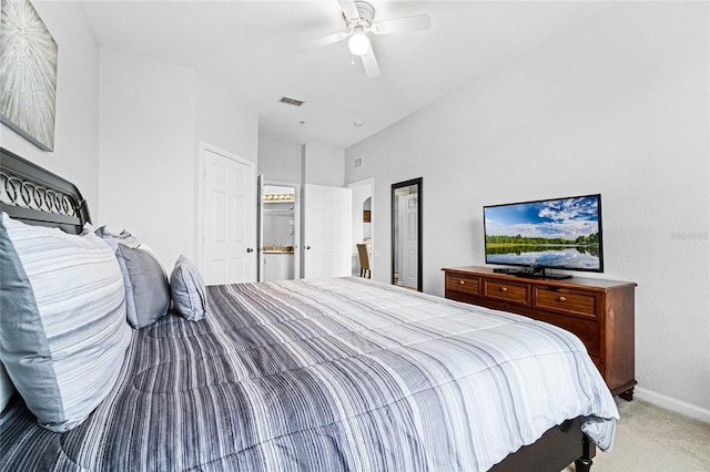 bedroom with ceiling fan, ensuite bathroom, and carpet flooring