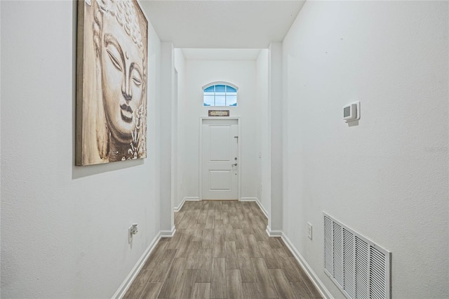 entryway with visible vents, baseboards, and wood finished floors