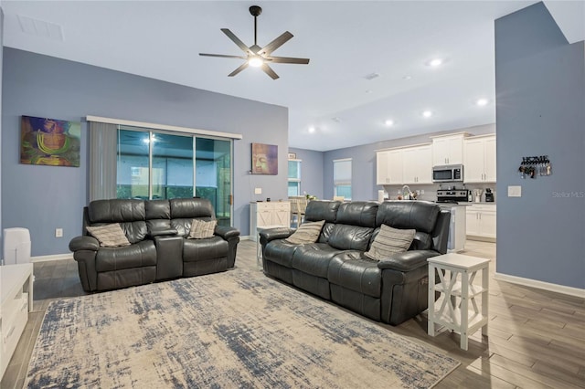 living room featuring wood-type flooring and ceiling fan