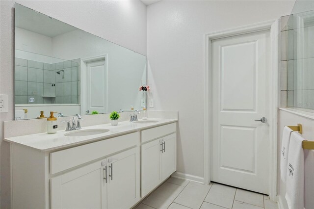 full bathroom featuring tile patterned floors, double vanity, tiled shower, and a sink