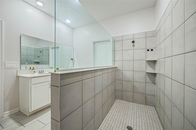 bathroom featuring vanity, a tile shower, and tile patterned floors