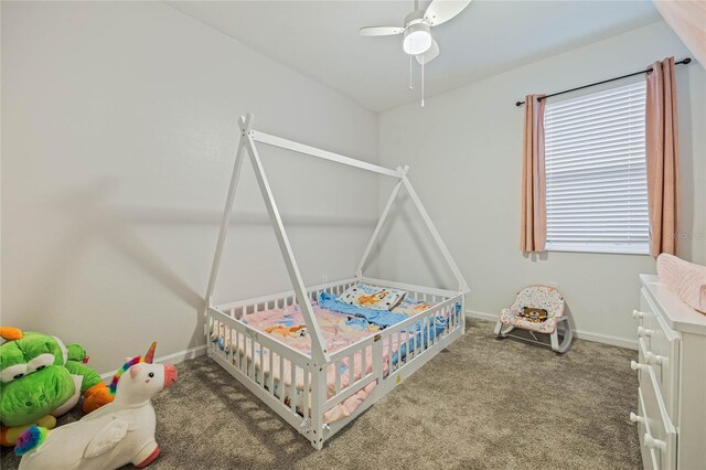 carpeted bedroom featuring ceiling fan and a crib