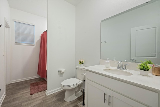 full bath with vanity, toilet, wood finished floors, and baseboards