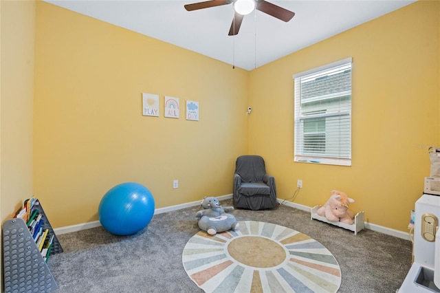 exercise area featuring baseboards, carpet floors, and ceiling fan