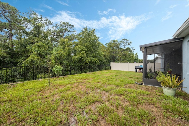 view of yard featuring a fenced backyard and a sunroom