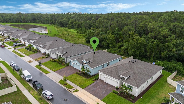 bird's eye view featuring a forest view, a water view, and a residential view