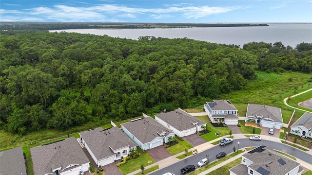 bird's eye view featuring a residential view, a wooded view, and a water view