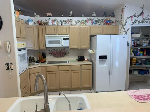 kitchen with a sink, light brown cabinetry, white appliances, and light countertops