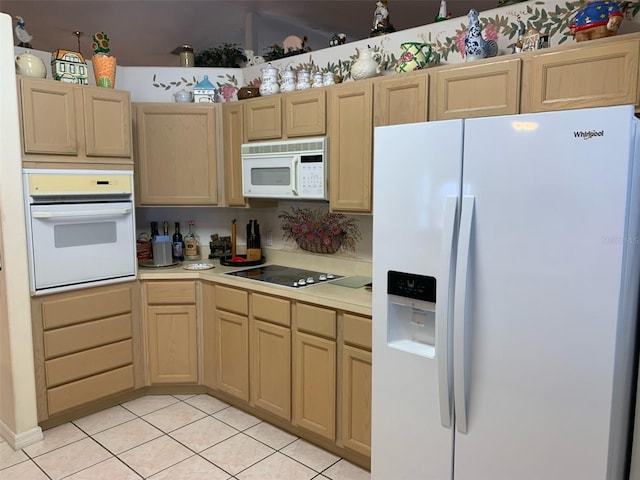 kitchen with light tile patterned floors, white appliances, light countertops, and light brown cabinetry