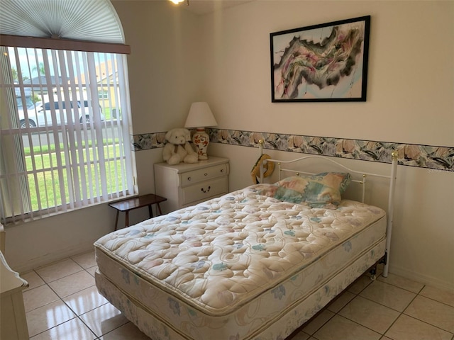 bedroom with light tile patterned floors and multiple windows