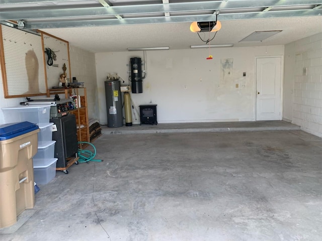 garage featuring water heater, concrete block wall, and a garage door opener