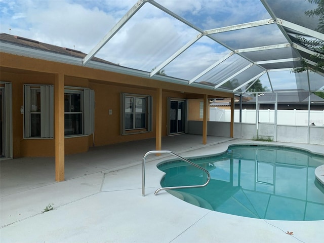 view of pool featuring glass enclosure and a patio