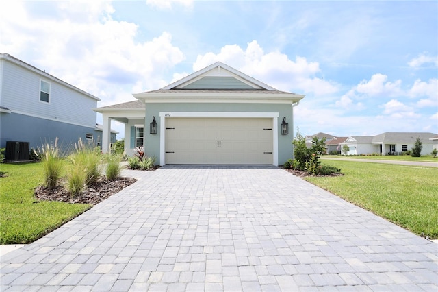 view of front facade with a front lawn, a garage, and central air condition unit