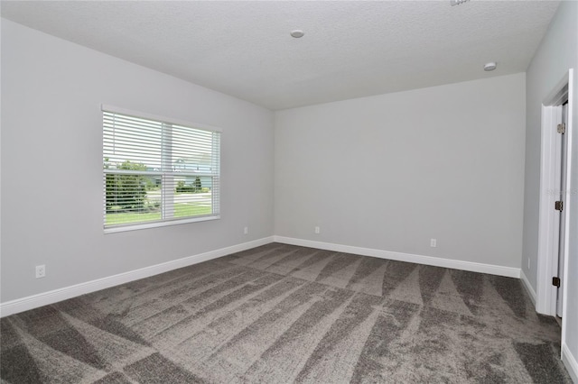 carpeted spare room with a textured ceiling