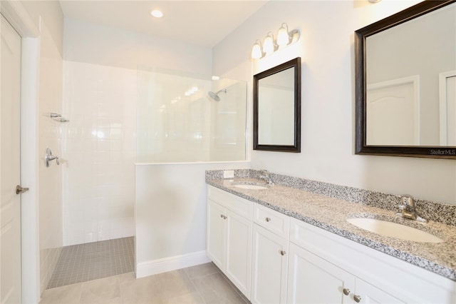 bathroom featuring vanity, tiled shower, and tile patterned flooring