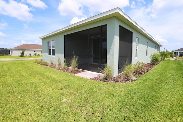 view of side of property featuring a yard and a sunroom