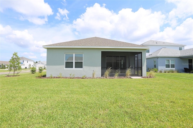 rear view of property with a lawn and a sunroom