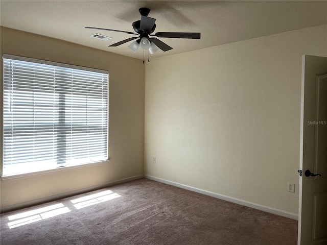 carpeted empty room featuring visible vents, ceiling fan, and baseboards