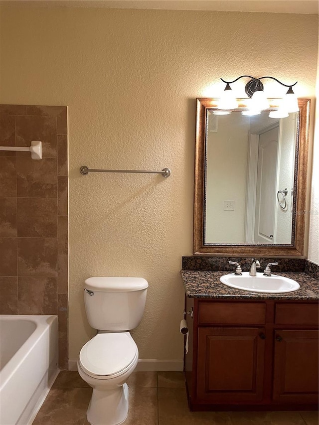 bathroom featuring a textured wall, tile patterned flooring, toilet, vanity, and baseboards