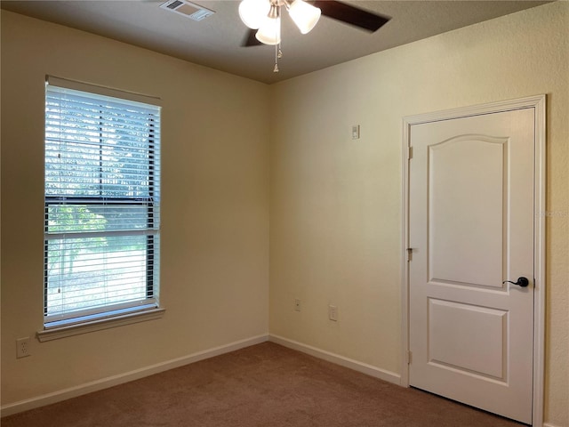 empty room featuring carpet flooring and ceiling fan