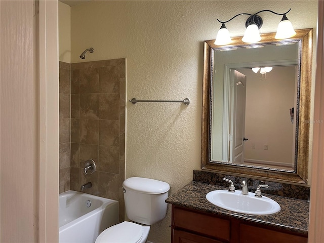 full bathroom with vanity, tiled shower / bath combo, and toilet