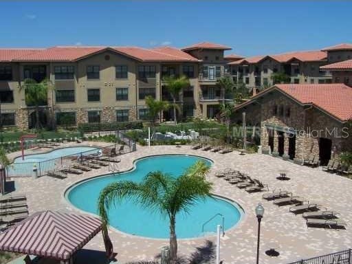 community pool with a patio area and fence