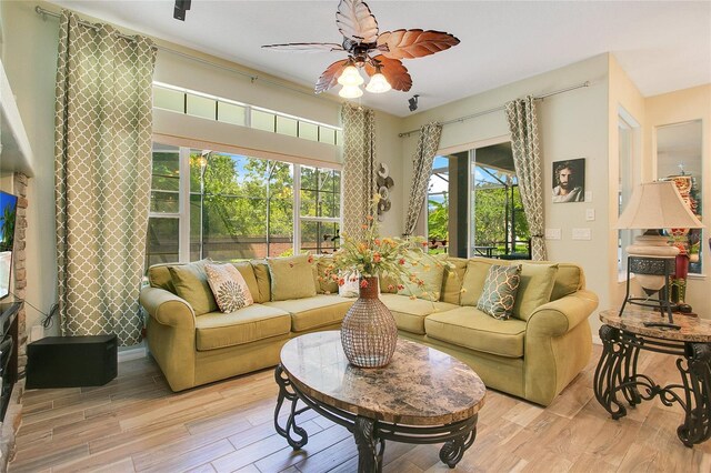 living room with ceiling fan and light wood-type flooring