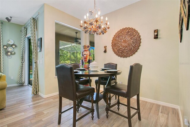 dining room with light wood-type flooring and ceiling fan with notable chandelier