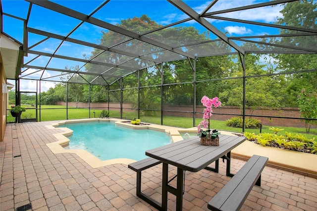 outdoor pool with a lanai, a patio area, and a lawn