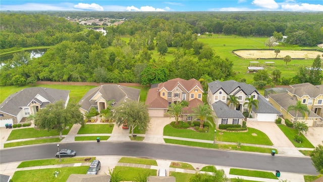 drone / aerial view featuring a residential view and a view of trees