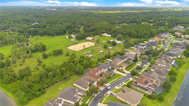 drone / aerial view featuring a wooded view and a residential view